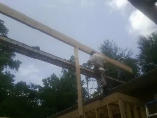 Carpenter setting a ridge beam over a new addition frame — Ice Dam Removal by Roofing Brothers in Tomah