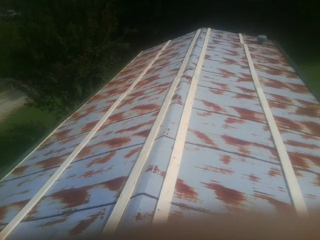 Rusted metal roof panels with new wood purlins before replacement — Storm Damage Roof Repair in Tomah by Roofing Brothers