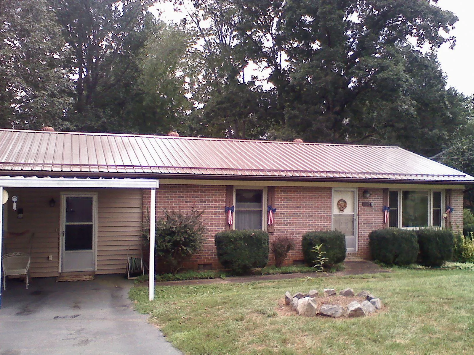 Bronze metal roof and carport on a brick ranch home — Roof Repair work by our crew in Tomah