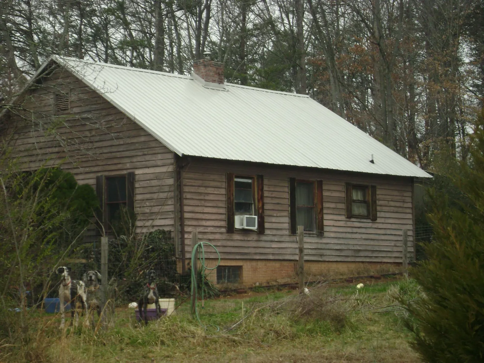 White metal roof on an old wood sided farmhouse, from a Metal Roof Installation job in Tomah